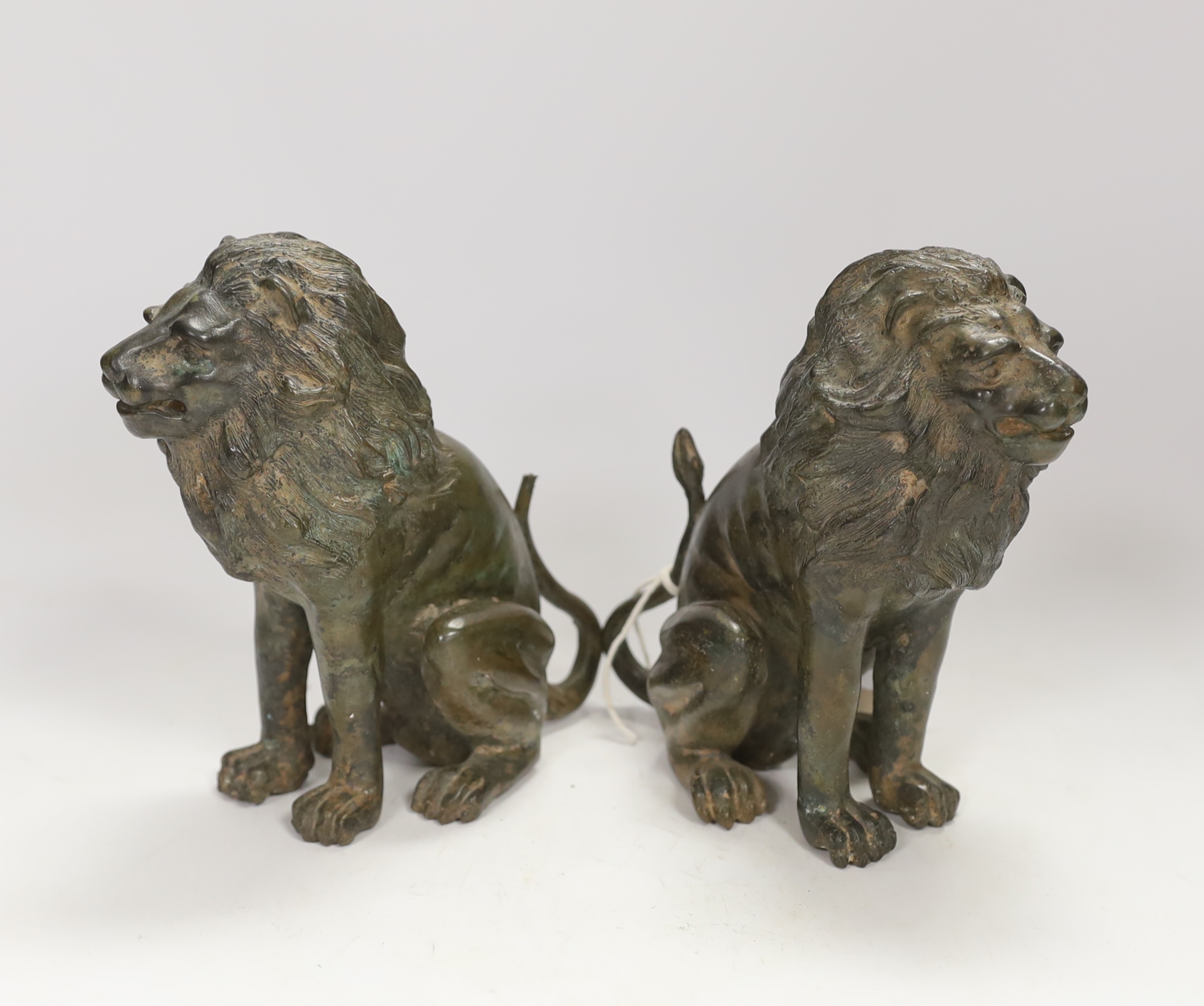 A pair of bronze models of seated lions, 17cm